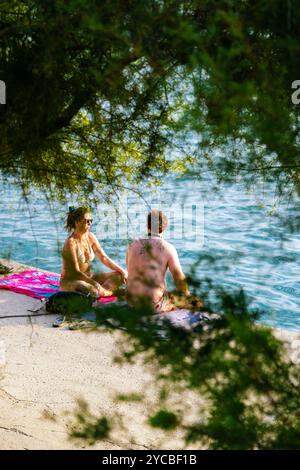 Homme et femme parlant et se relaxant à Bacvice Beach, Split, Croatie Banque D'Images