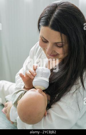 La mère nourrit le lait maternisé du nouveau-né au biberon. Gros plan de bébé caucasien. Nutrition infantile. Problèmes de l'allaitement maternel. La maternité. Concept rea Banque D'Images