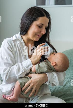 La mère nourrit le lait maternisé du nouveau-né au biberon. Gros plan de bébé caucasien. Nutrition infantile. Problèmes de l'allaitement maternel. La maternité. Concept rea Banque D'Images