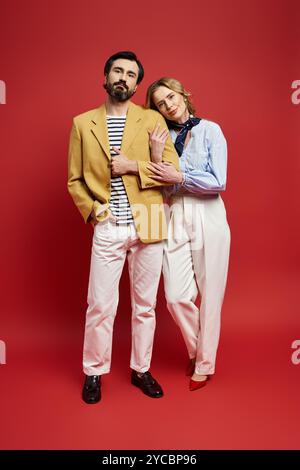 Un couple d'âge moyen se tient étroitement ensemble, exsudant confiance et style dans une tenue moderne. Banque D'Images