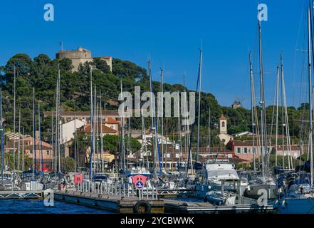 France, Porquerolles, 9 juin 2024 : bateaux dans le port de l'île de Porquerolles, et Fort Sainte Agathe Banque D'Images