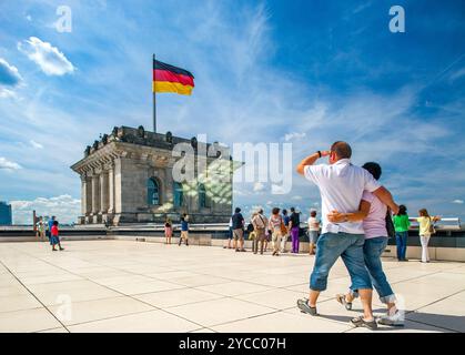 Berlin, Allemagne, juillet 29 2009, les touristes se rassemblent sur le toit-terrasse du Reichstag, en admirant la vue sur Berlin et le drapeau allemand agité au-dessus. Banque D'Images