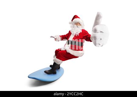 Santa claus chevauchant une planche de surf et gestuelle pouces vers le haut isolé sur fond blanc Banque D'Images