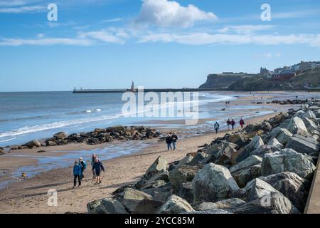 Whitby, Royaume-Uni. 22 octobre 2024. Les gens aiment marcher sur la plage de Whitby sur la côte du Yorkshire du Nord dans le soleil d'automne glorieux et les températures sur le milieu de l'adolescence centigrade. Après un week-end orageux et humide, le temps britannique est dans une période plus stable. Crédit : Julian Eales/Alamy Live News Banque D'Images