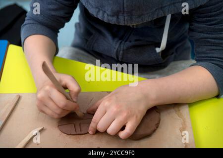 Écolier travaillant l'argile dans une classe d'art. Banque D'Images