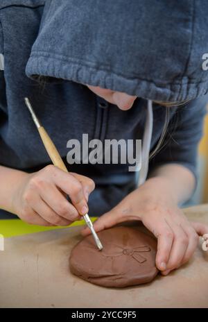 Écolier travaillant l'argile dans une classe d'art. Banque D'Images