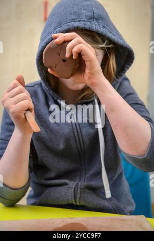 Écolier travaillant l'argile dans une classe d'art. Banque D'Images