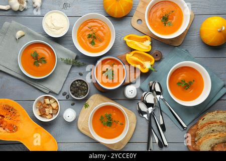 Composition plate de pose avec une délicieuse soupe de citrouille sur une table en bois gris Banque D'Images