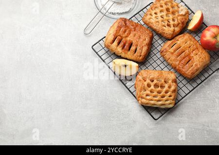 Délicieuses pâtisseries feuilletées avec garniture de fruits et pommes sur table grise, vue de dessus. Espace pour le texte Banque D'Images