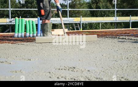 Ouvriers remplissant le sol du deuxième étage avec le béton, le noyau et le bâtiment de construction de coquille Banque D'Images