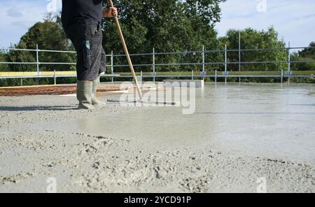 Ouvriers remplissant le sol du deuxième étage avec le béton, le noyau et le bâtiment de construction de coquille Banque D'Images