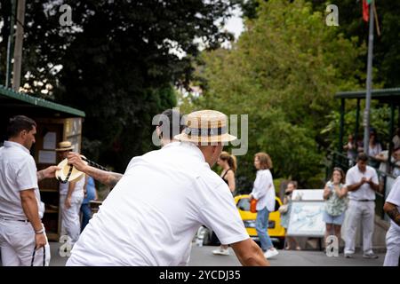 Monte, Madère - 01.10.2024 : cavalier de luge traditionnel avec chapeau de paille en bois. Île de Madère, Portugal Banque D'Images