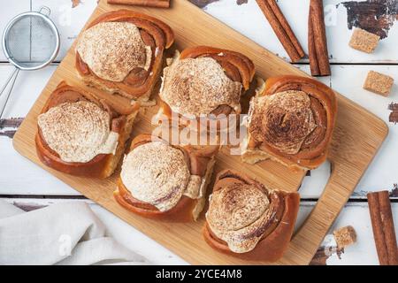 Kanelbulle petits pains à la cannelle avec crème au beurre sur une table en bois rustique. Pâtisseries fraîches faites maison Banque D'Images