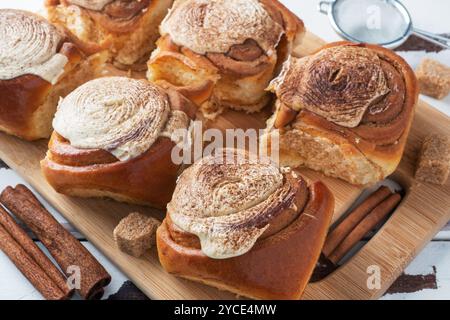 Kanelbulle petits pains à la cannelle avec crème au beurre sur une table en bois rustique. Pâtisseries fraîches faites maison Banque D'Images