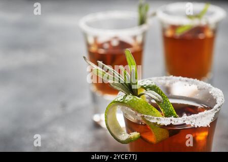 Verre avec de l'alcool, du sel et de la chaux sur un fond de béton foncé. Tequila au whisky cognac. Le concept du parti. Espace de copie de mise au point sélective. Banque D'Images