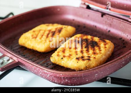 Schnitzel frit sur la poêle à gril. Deux morceaux de cordon Bleu avec jambon et fromage dans une poêle Banque D'Images