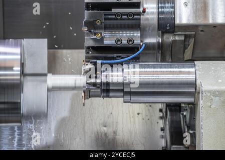 La machine de tournage CNC formant couper les pièces métalliques. Travail des métaux de haute technologie par machine de tournage CNC, graphie Banque D'Images