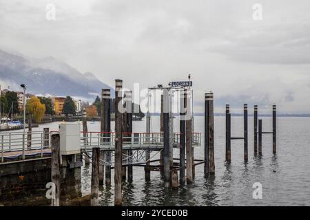 Incroyable vue brumeuse sur la jetée et la ville Locarno à distance et la couleur des feuilles d'automne nature et Alpes suisses, montagnes enneigées -Alpes suisses Banque D'Images