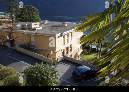 12-10-2022 Lugano, Suisse. Vue sur l'immeuble d'appartements à Lugani sur la côte du lac. Beau jardin à côté du bâtiment et de la côte Banque D'Images