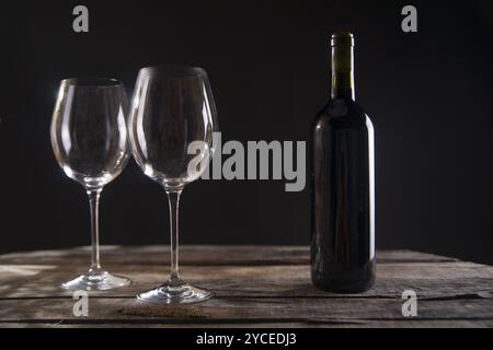 Une bouteille de vin rouge en verre fond sombre Banque D'Images