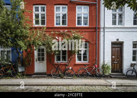 Copenhague, Danemark, 12 août 2016. Pittoresques vieilles maisons colorées en briques dans le centre-ville historique de Copenhague une journée nuageuse d'été, avec bicyc Banque D'Images