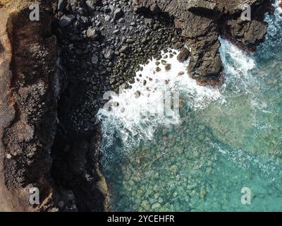 Vue aérienne sur les rochers et les vagues dans un paysage volcanique avec lave Banque D'Images