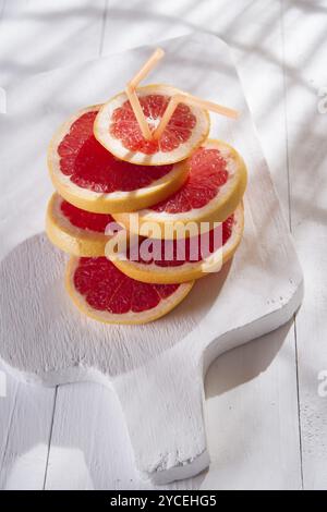 Apéritif avec tranches de pamplemousse rouge sur la bordure blanche Banque D'Images