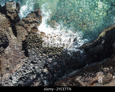 Vue aérienne sur les rochers et les vagues dans un paysage volcanique avec lave Banque D'Images