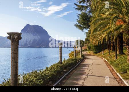 Vue imprenable sur le jardin Helenium avec de petites colonnes et chemin de jardin et l'eau du lac de Lugano, journée ensoleillée en décembre. Grand cèdre sur le rivage Banque D'Images