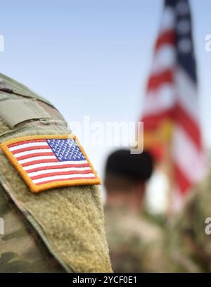 SOLDATS AMÉRICAINS. Armée AMÉRICAINE. Drapeau américain sur l'uniforme militaire américain. Soldats sur le terrain de parade depuis l'arrière. Fête des anciens combattants. Memorial Day. Banque D'Images