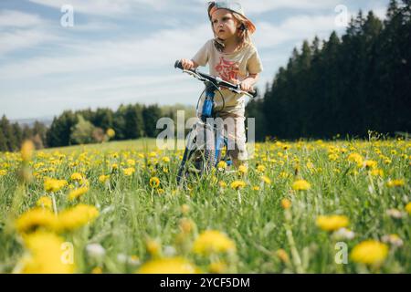 Fille faisant du vélo dans un pré Banque D'Images