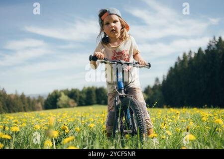 Fille faisant du vélo dans un pré Banque D'Images