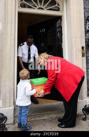 Le jeune militant William, âgé de 2 ans, et la députée travailliste Sharon Hodgson présentent la pétition future Generations Act au 10 Downing Street, exhortant le premier ministre britannique à tenir les organismes publics responsables de l’impact à long terme de leurs décisions sur les enfants, dans le cadre d’une initiative organisée par le fabricant d’aliments pour bébés et enfants Ella’s Kitchen. Date de publication : mercredi 23 octobre 2024. Le pays de Galles a introduit la première loi sur les générations futures au monde en 2015, et en septembre 2024, l'ONU a adopté une Déclaration s'engageant à prendre en considération les enfants lors de l'élaboration des politiques. Près de 14 000 ont signé la pétition Banque D'Images