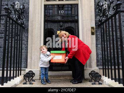 Le jeune militant William, âgé de 2 ans, et la députée travailliste Sharon Hodgson présentent la pétition future Generations Act au 10 Downing Street, exhortant le premier ministre britannique à tenir les organismes publics responsables de l’impact à long terme de leurs décisions sur les enfants, dans le cadre d’une initiative organisée par le fabricant d’aliments pour bébés et enfants Ella’s Kitchen. Date de publication : mercredi 23 octobre 2024. Le pays de Galles a introduit la première loi sur les générations futures au monde en 2015, et en septembre 2024, l’ONU a adopté une Déclaration s’engageant à prendre en compte les enfants lors de l’élaboration des politiques. Près de 14 000 ont signé la pétition Banque D'Images