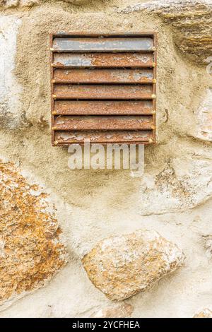 Photographie d'une grille de ventilation sur un mur, vieux mur en pierre naturelle, façade de maison, image de fond Banque D'Images