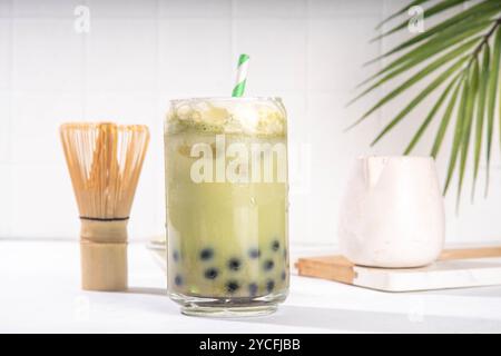 Thé à bulles vert matcha boba avec perle de tapioca. Boisson glacée froide asiatique tendance avec boules de tapioca foncées et crème fouettée non laitière, espace copie Banque D'Images