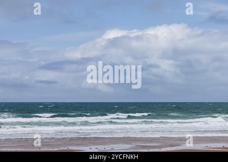 Ciel bleu éclatant avec des nuages moelleux sur la mer vert profond à Strandhill, Irlande, mettant en valeur les couleurs vives de l'océan et du ciel Banque D'Images