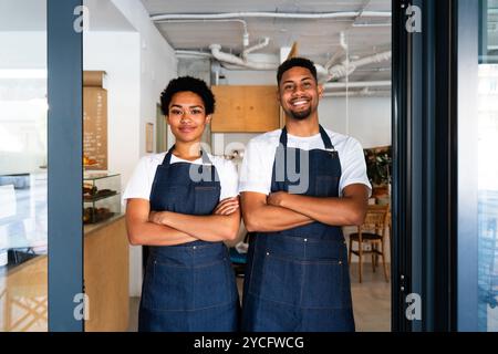 Boulangerie, portrait heureux de l'homme noir hispanique et la femme dans le café prêt à servir la pâtisserie, le café et les aliments cuits au four - serveur confiant barista par comptoir Banque D'Images