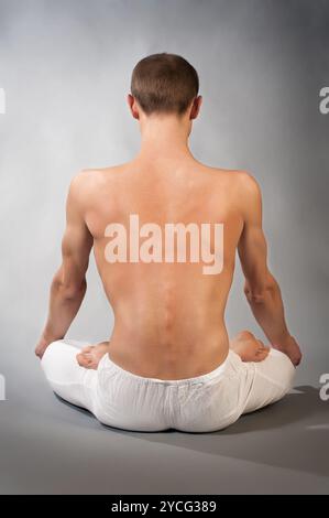 Dos de jeune homme en position yoga Banque D'Images