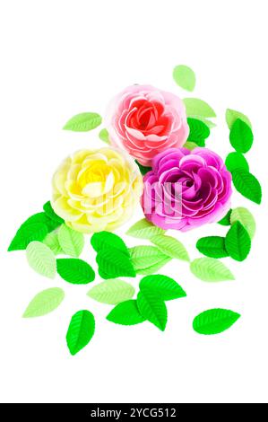 Trois roses artificielles et feuilles vertes faites de SO Banque D'Images