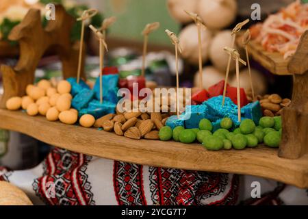 Présentoir de collations coloré avec assortiment de friandises sur plateau en bois. Banque D'Images