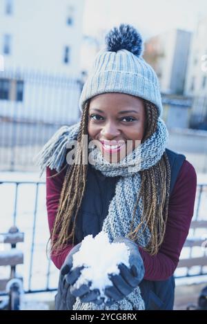 Portrait, boule de neige et femme en hiver, en plein air et excité pour la neige, le jeu et le froid avec le changement climatique. Glace, gel et vêtements pour la météo Banque D'Images