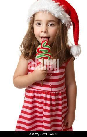 Santa girl licking Christmas Tree lollipop candy Banque D'Images