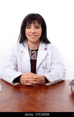 Smiling doctor sitting at desk Banque D'Images