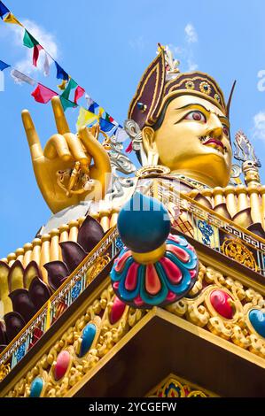 Golden Buddha sculpture dans le monastère tibétain plus de ciel bleu avec des drapeaux de prière. Focus on hand Banque D'Images