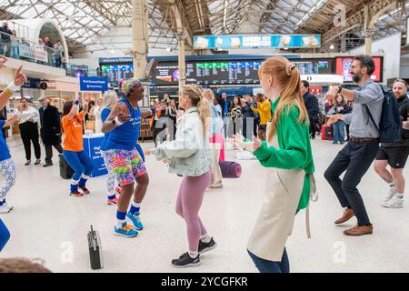 USAGE ÉDITORIAL EXCLUSIF Derrick Errol Evans, également connu sous le nom de Mr Motivator, dirige les propriétaires de petites entreprises dans une mob éclair à la gare Victoria de Londres pour célébrer le lancement au Royaume-Uni de constant contact, une plateforme de marketing numérique et d'automatisation. Date de la photo : mercredi 23 octobre 2024. Banque D'Images