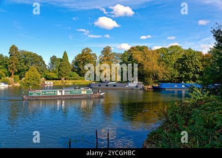 Un bateau étroit naviguant sur la Tamise à Shepperton un jour d'automne ensoleillé Surrey Angleterre Royaume-Uni Banque D'Images