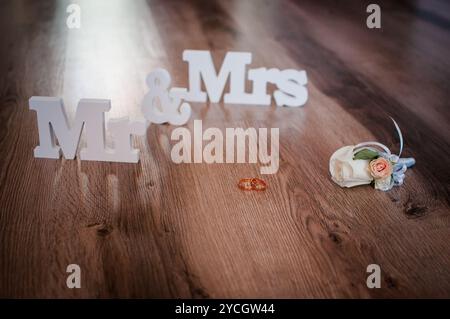 Décor de mariage élégant avec anneaux et arrangement floral sur parquet. Banque D'Images