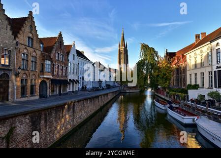 Tour de l'église notre-Dame, bâtiments médiévaux et leur réflexion sur le canal de Dijver de Nepomucenusbrug juste après le lever du soleil. Bruges, Belgique. Banque D'Images