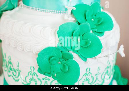 Gâteau de mariage floral sarcelle et blanc élégant avec décorations d'orchidée. Banque D'Images